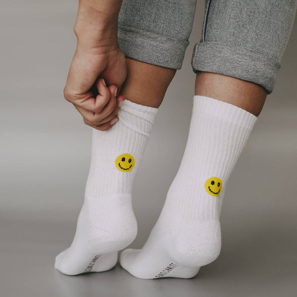 Witte sokken met een geel smileygezichtje