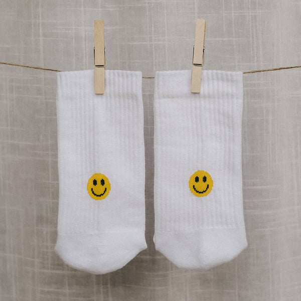 Witte sokken met een geel smileygezichtje